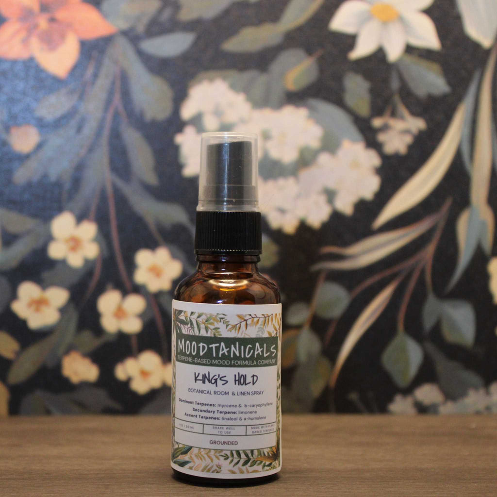 Bottle of Moodtanicals King's Hold botanical room & linen spray against a floral background
