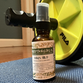 Bottle of 'Woodtanicals' King's Hold room & linen spray on a textured surface with a yellow object in the background.
