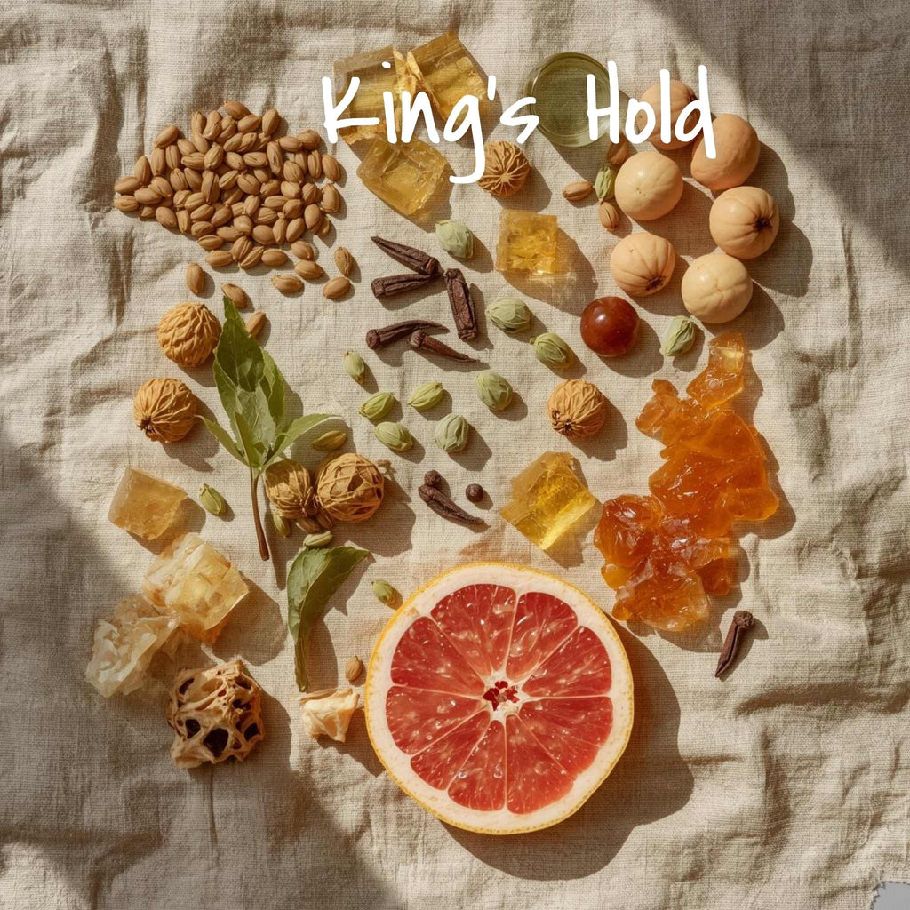 Spices and a sliced grapefruit arranged on a textured surface with 'King's Hold' branding.