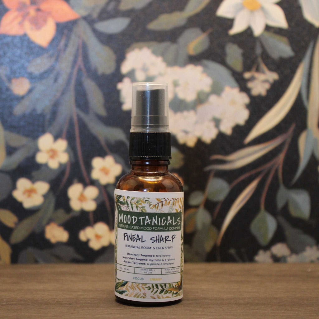 Bottle of Moodtanicals Pineal Sharp on a wooden surface with a floral background